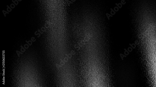 Fotografía Abstract dark frosted glass texture with a strong grainy effect and deep wavy undulations reflecting bright light