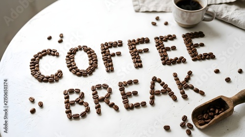 Coffee break spelled in roasted coffee beans on a white table with a cup of black coffee and a wooden scoop top view composition