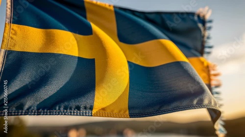 Waving Swedish flag in sunlight with blurred natural background showing national pride and culture