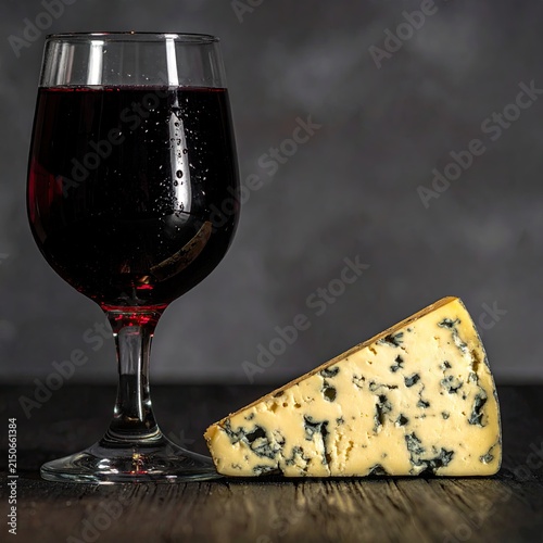 A Wedge of Blue Cheese Paired with Red Wine on a Dark Surface.