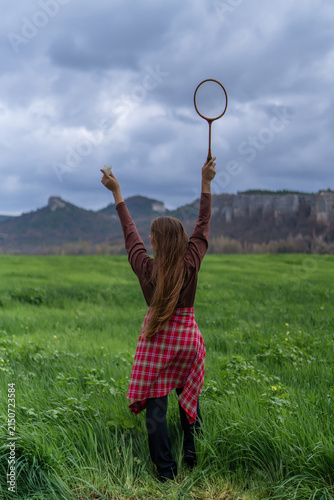 Bild auf Leinwand Triumphant woman holding badminton racket and shuttlecock aloft while standing i