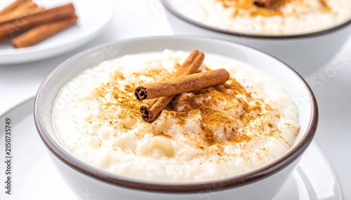 Cinnamon rice pudding. Authentic Arroz con leche dessert served in a bowl, richly spiced with a dusting of ground cinnamon and whole sticks.