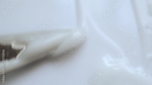 Spatula spreading white cosmetic cream in smooth, satisfying motion 