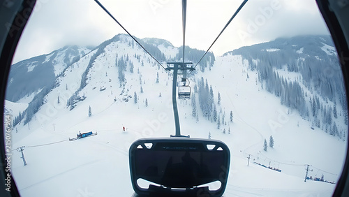 View from inside a ski lift cabin looking down at a steep snowy slope.
