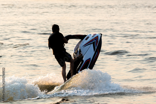 Canvastavla Man performing a trick on a stand-up jet ski in the water making splash waves