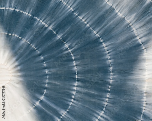 Indigo blue shibori tie dye fabric with hand-dyed resist patterns and slubbed cotton texture for textile design and apparel backgrounds