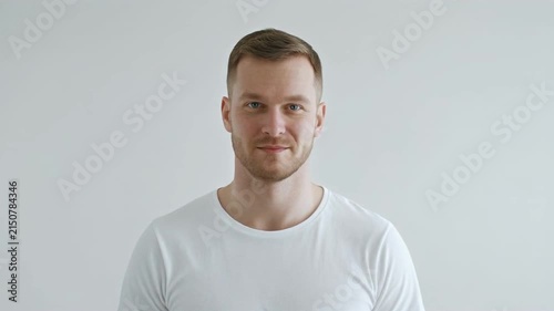 young man transitioning from neutral to smiling in white shirt