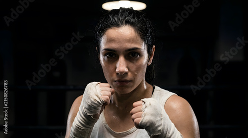 Close Up Female Boxer With Wrapped Fists and Intense Focused Gaze, Strength and Determination in Sports Portrait