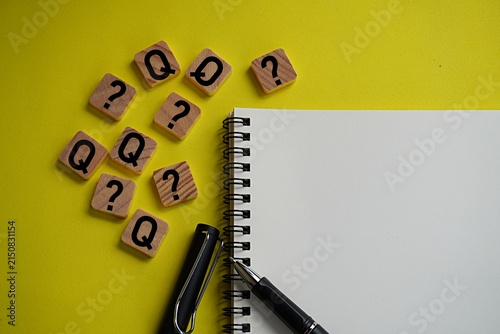 Wooden block with letter Q and question mark symbol, icon for question. Learning concept. Blank note to write answer text
