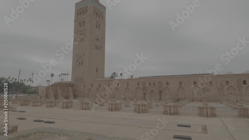 Cinematic handheld pan capturing the grand scale of Koutoubia Mosque Marrakech