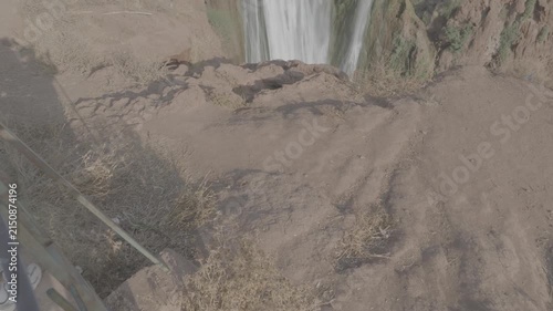 Close up panning shot of red sandstone cliffs and rushing water at Ouzoud Falls