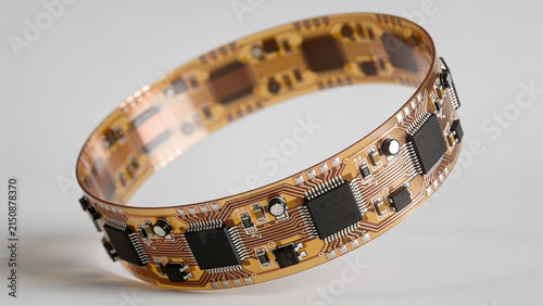High-resolution professional stock photo of flexible printed circuit board FPCB with microchips and copper traces on neutral background.