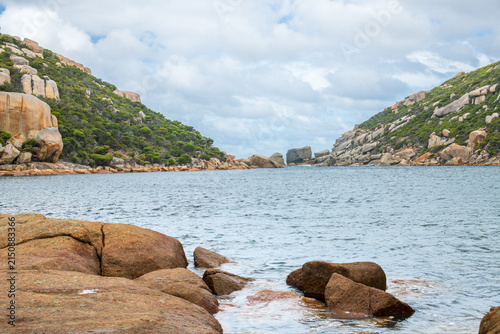 Obraz na płótnie Scenic view of Wychinicup Inlet with calm water, granite rocks, and green hills under soft cloud cover