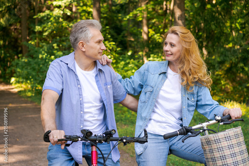 Bild auf Leinwand Mature Couple Beside Two Bicycles on a Forest Road