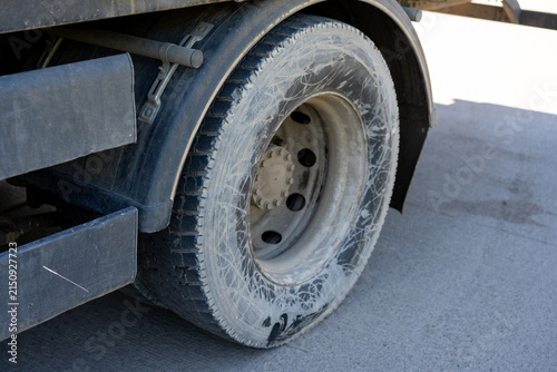 Konstfotografi Close-up of a dusty truck tire and mudguard on a paved surface