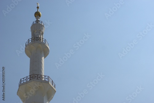 Fotografie white mosque minaret tower with golden crescent against blue sky
