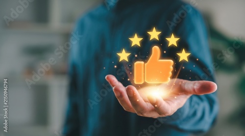 Customer satisfaction featuring a glowing thumbs up icon surrounded by five gold stars held in an open palm, symbolizing positive feedback, top rating, excellent service quality