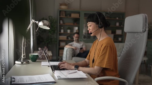 Asian call center agent working remotely from her living room