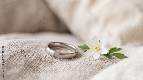 Minimalist platinum wedding ring styled with a delicate white wildflower