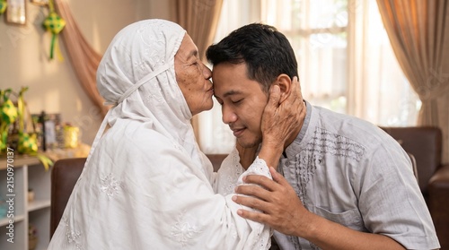 Muslim Mother Kissing Son Forehead During Eid Celebration at Home