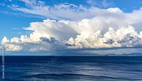Majestic cumulus clouds over tranquil ocean horizon