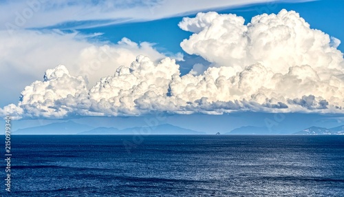 Majestic cumulus clouds over tranquil ocean horizon