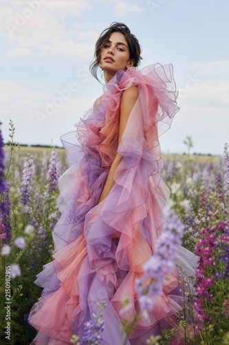 model in stunning pink-and-purple ombre ruffled tulle gown featuring dramatic, billowy layers 