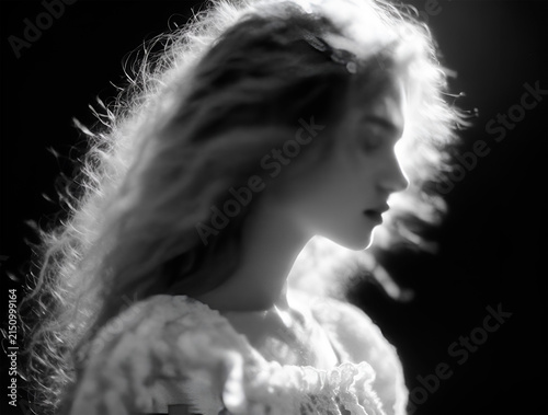 Beautiful girl with fluffy wavy hair, profile portrait, black and white, romantic, close-up, slight motion blur, soft dreamy aesthetic.