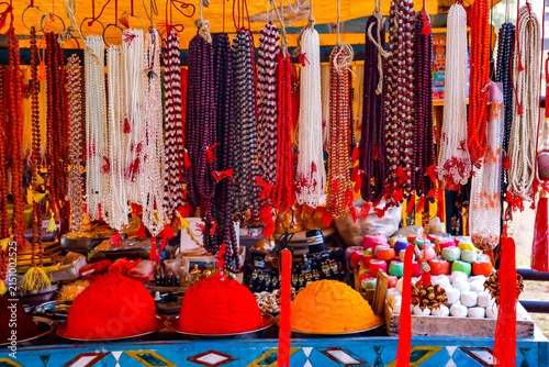 Hanging strings of traditional Indian prayer beads, japa mala and rudraksha necklaces on display at a market stall in Hampi, India. Spiritual religious accessories, meditation items and souvenirs.
