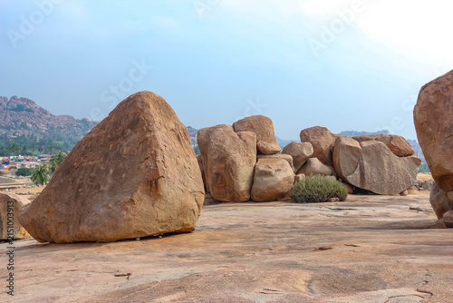 Giant natural granite boulders and rock formations on a rocky hill landscape in Hampi, India. Unique geological scenery, historic archaeological site, outdoor nature destination.