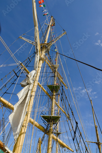 Fotografie Low-angle view looking up at tall sailing ship masts, spars, ropes and rigging against a clear blue sky