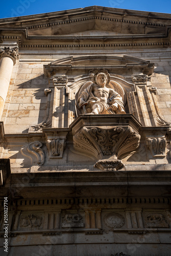 Fotografie Classic historic building stone facade with antique angel statue sculpture in alcove close up
