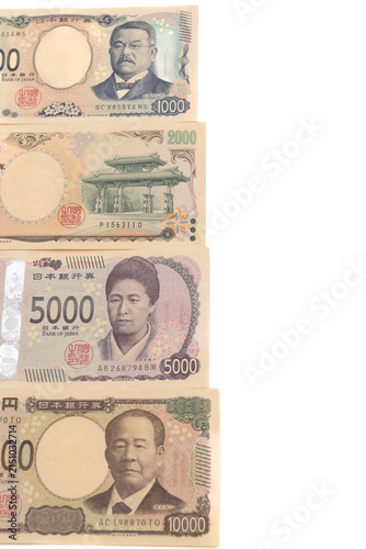 Top view of Japanese yen banknotes front sides stacked vertically: new 1,000 yen, rare 2,000 yen, new 5,000 yen, and new 10,000 yen (Series E). Isolated on white background.