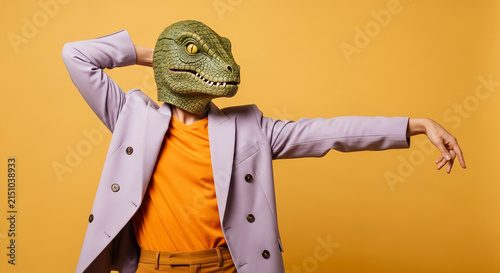 Person in a reptilian mask and lilac blazer, posing with arm raised, symbolizing unexpected duality, mystery, and a playful paradox