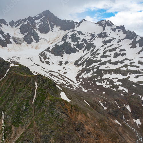 Mountains covered in snow with clouds overhead