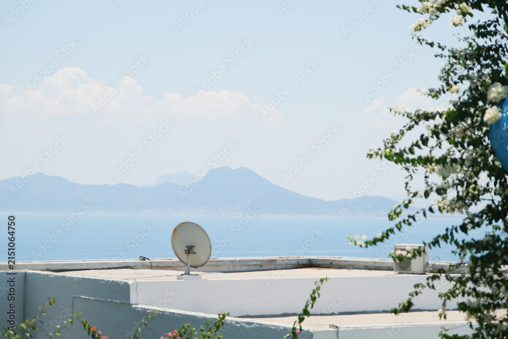 Fototapeta premium White Building with Blue Shutters and Bougainvillea in Mediterranean Town