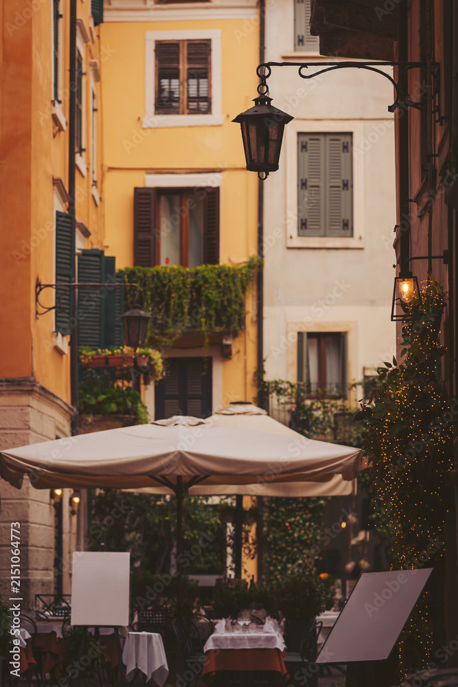Fototapeta premium Charming alleyway restaurant under a warm lantern glow in a vibrant cityscape