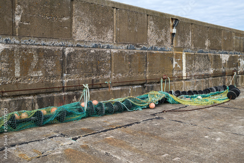 фотографія Fishing net spread along the concrete harbour wall at Buckie Harbour in Moray Sc