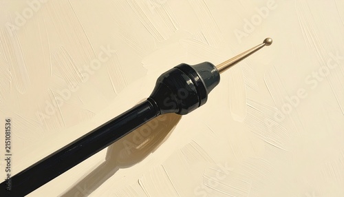 Close up of black mechanical pencil tip on white surface.