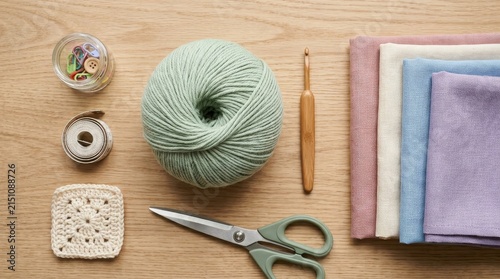 Knitting supplies arranged on wooden surface for crafting.