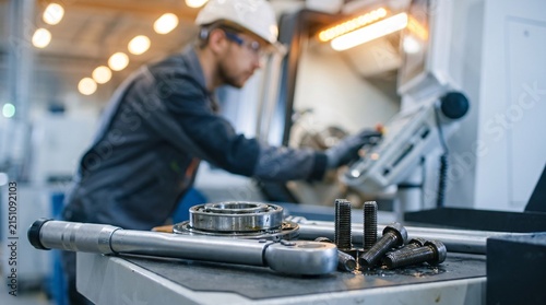 Precision metal parts and tools resting on a workbench in an automated factory facility