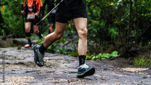 Bild auf Leinwand Trail runner navigating a rocky forest path during an outdoor endurance race