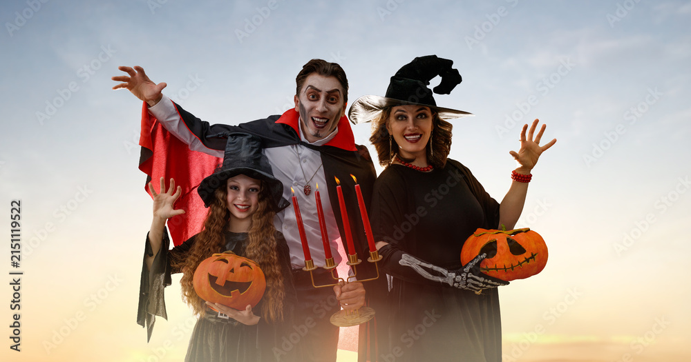 Obraz premium Happy Family Dressed in Halloween Costumes Outdoors at Sunset