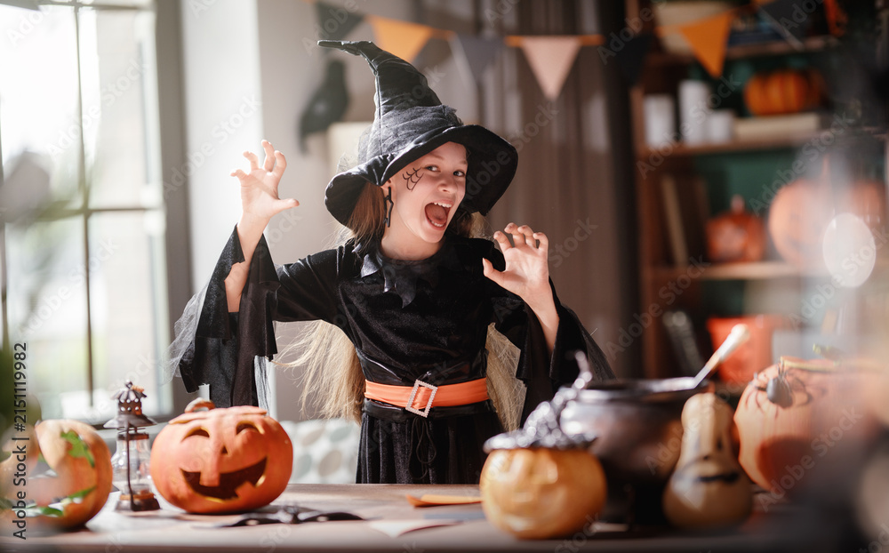 Obraz premium Happy Child in Witch Costume Celebrating Halloween at Home