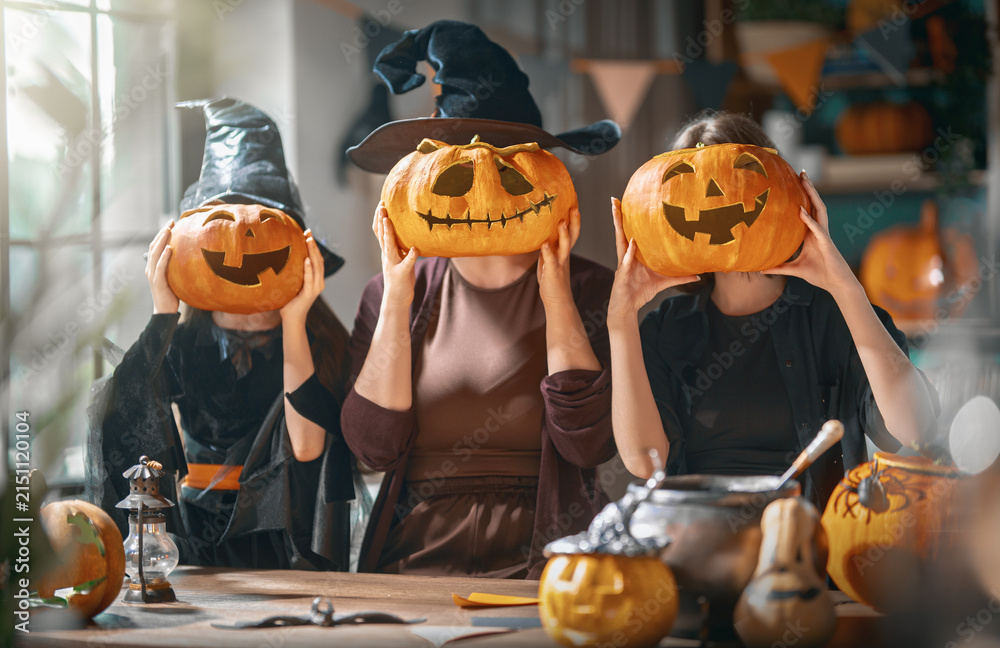 Obraz premium Happy Family Celebrating Halloween with Pumpkin Jack-O-Lanterns