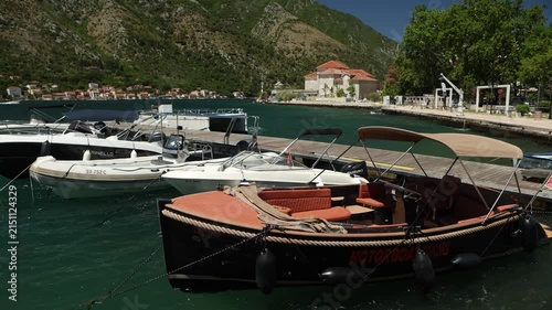 boats are moored at the pier of the picturesque Bay of Kotor, rocking on the waves