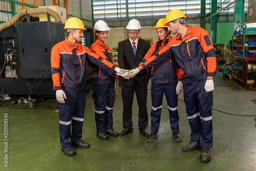 Engineer factory worker team hard hat uniform teamwork industry group wearing safety gear join hand inside plant