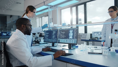 Scientists analyzing data in modern laboratory with computers and equipment