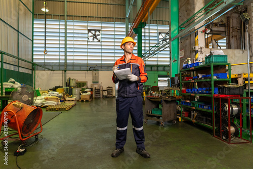 Engineer factory worker safety helmet industrial uniform clipboard, machinery workshop floor with shelf and tool storage
