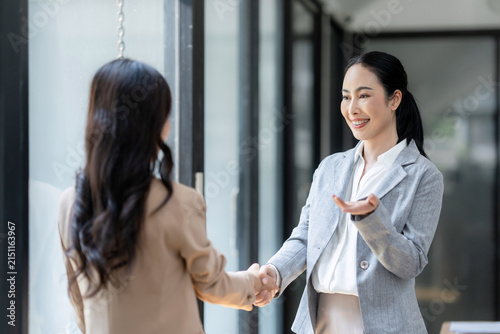 Businesswomen shaking hands in a professional office setting